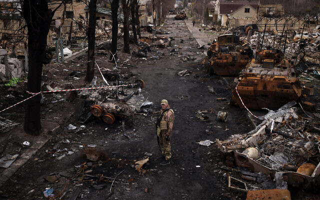 A Ukrainian serviceman stands amid destroyed Russian tanks in Bucha, on the outskirts of Kyiv, Ukraine, April 6, 2022. (AP Photo/Felipe Dana, File)