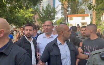 Religious Zionism MK Simcha Rothman leaving the Hebrew Book Week Fair amid anti-judicial overhaul protests at Sarona Market, Tel Aviv, June 18, 2023. (Twitter video screenshot: used in accordance with Clause 27a of the Copyright Law)