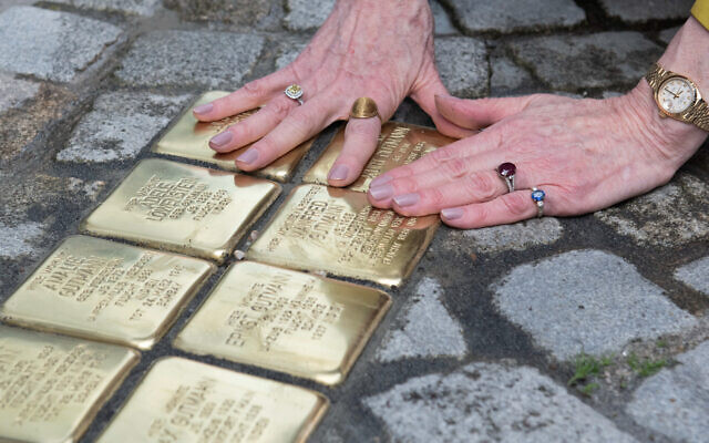 US Ambassador to Germany Amy Gutmann touches the freshly laid 'Stolpersteine' (stumbling stones) for members of her family in Feuchtwangen, Bavaria, on May 30, 2023. (Thomas Kienzle/AFP)