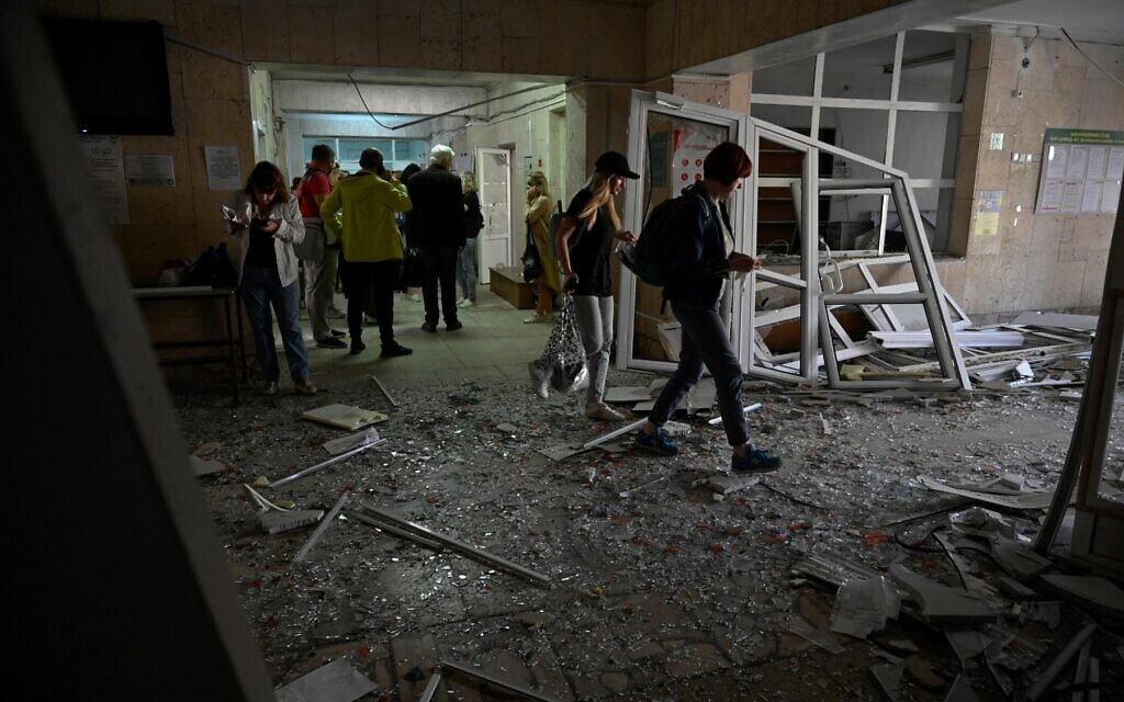 Visitors walk through debris in the hall of a health clinic damaged as a result of a downed missile explosion in Kyiv, on June 1, 2023. (Sergei Chuzavkov/AFP)