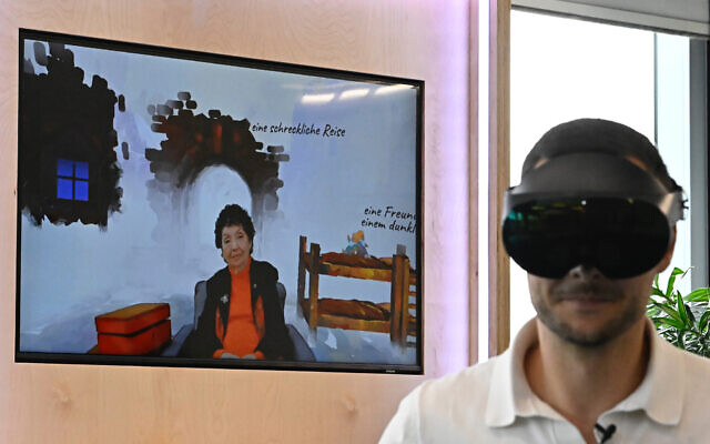 A man wearing VR goggles is seen next to a screen depicting Holocaust survivor Inge Auerbacher at the Meta hub in Berlin on June 6, 2023. (Tobias Schwarz/AFP)