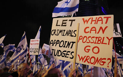 Israelis hold up national flags and placards as they protest the hard-right government's controversial judicial reform plans, in Tel Aviv on June 10, 2023. (JACK GUEZ / AFP)