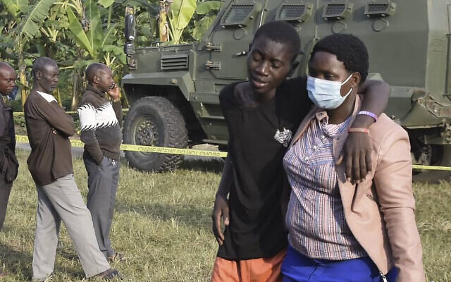 A boy is comforted at the scene of an attack in Mpondwe, Uganda, on June 17, 2023, at the Mpondwe Lhubiriha Secondary School. (AFP)