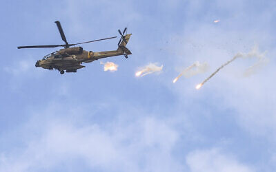 An Israeli Air Force AH-64 Apache attack helicopter releases flares during an Israeli army raid in Jenin in the West Bank on June 19, 2023. (Jaafar ASHTIYEH / AFP)