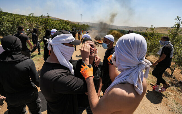 Members of the Druze community assist a demonstrator who was injured during a protest in the village of Majdal Shams in the Golan Heights on June 21, 2023, against a wind turbine project (Photo by Jalaa MAREY / AFP)