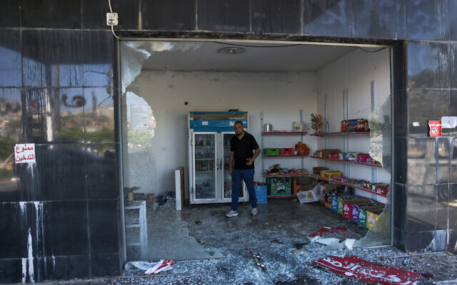 A man checks the convenience store of a gas station, reportedly vandalized by settlers, in al-Lubban al-Sharqiya in the West Bank on June 21, 2023. (AHMAD GHARABLI / AFP)