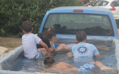 Children frolic in a makeshift pool in the trunk of a pickup truck in June, 2023. (Israel Police)