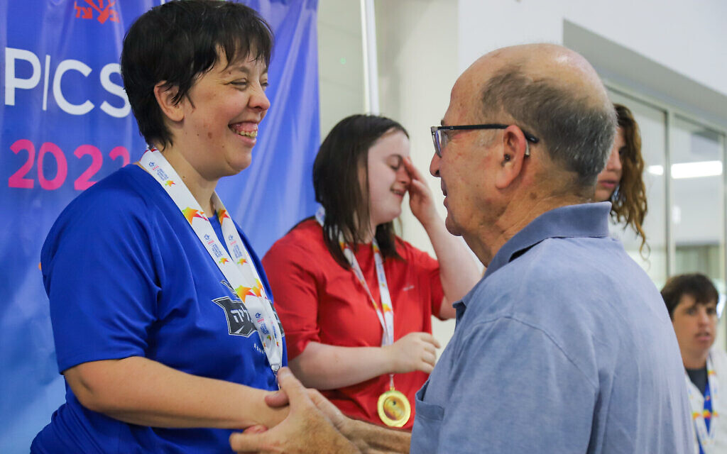 Special Olympics swimmer Avital Naveh accepting a medal from organization chairman Moshe Ya'alon at the national games in October 2022. (Courtesy)