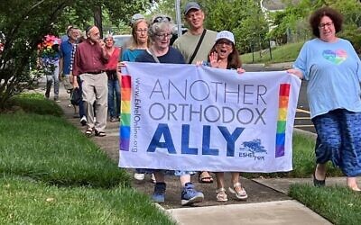 Members and allies of Eshel, an advocacy group for LGBTQ Orthodox Jews and their families, march in Highland Park, New Jersey, as Pride flags are restored to a public street after they had been removed at the request of Orthodox rabbis, June 26, 2023. (Courtesy of Eshel via JTA)