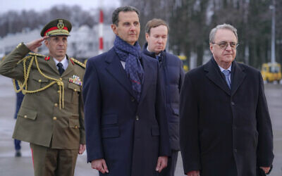 Visiting Syrian President Bashar Assad, left, and Mikhail Bogdanov, right, deputy minister of Foreign Affairs of Russia and Special Representative of the President of Russia for the Middle East, review an honor guard during a welcome ceremony upon Assad's arrival at Vnukovo airport in Moscow, Russia, March 14, 2023. (SANA via AP)