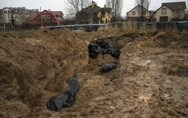 lie in a mass grave in Bucha, on the outskirts of Kyiv, Ukraine, after it was retaken from Russian forces, April 3, 2022. (Rodrigo Abd/AP)