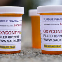 FILE: Fake pill bottles with messages about OxyContin maker Purdue Pharma are displayed during a protest outside the courthouse where the bankruptcy of the company is taking place in White Plains, NY, on Aug. 9, 2021. (AP/Seth Wenig)