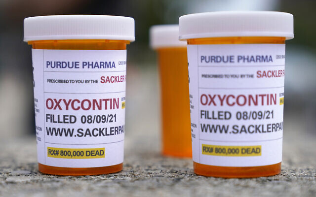 FILE: Fake pill bottles with messages about OxyContin maker Purdue Pharma are displayed during a protest outside the courthouse where the bankruptcy of the company is taking place in White Plains, NY, on Aug. 9, 2021. (AP/Seth Wenig)