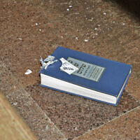 This image released by the Department of Justice shows a bullet-damaged prayer book that was introduced as a court exhibit, Tuesday, May 30, 2023, in the federal trial of Robert Bowers in Pittsburgh. (Department of Justice via AP)
