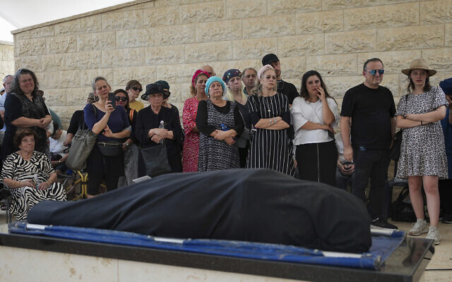 Mourners gather around the body of Chana Nachenberg, during her funeral in Modiin, Israel, Thursday, June 1, 2023. Nachenberg died on Wednesday, nearly 22 years after she was critically wounded in a 2001 Palestinian suicide bombing at a Jerusalem restaurant. (AP Photo/Tsafrir Abayov)