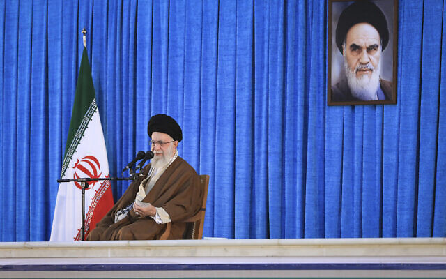 Iran's Supreme Leader Ayatollah Ali Khamenei speaks during a ceremony commemorating the death anniversary of the late revolutionary founder Ayatollah Khomeini, shown in the poster at top right, at his mausoleum just outside Tehran, Iran, June 4, 2023. (Office of the Iranian Supreme Leader via AP)