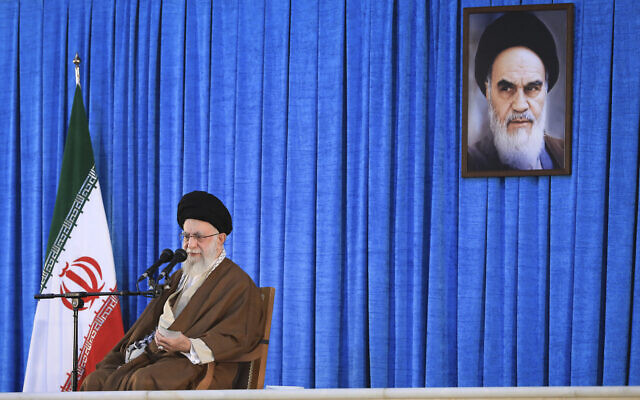 In this picture released by an official website of the office of the Iranian supreme leader, Supreme Leader Ayatollah Ali Khamenei speaks during a ceremony commemorating the death anniversary of the late revolutionary founder Ayatollah Khomeini, shown in the poster at top right, at his mausoleum just outside Tehran, Iran, June 4, 2023. (Office of the Iranian Supreme Leader via AP)