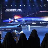 Women look at Fattah missile in a ceremony in Tehran, Iran, Tuesday, June 6, 2023. Iran is claiming that it has created a hypersonic missile capable of traveling at 15 times the speed of sound. (Hossein Zohrevand/Tasnim News Agency via AP)
