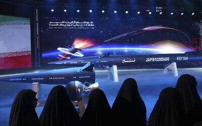 Women look at Fattah missile in a ceremony in Tehran, Iran, Tuesday, June 6, 2023. Iran is claiming that it has created a hypersonic missile capable of traveling at 15 times the speed of sound. (Hossein Zohrevand/Tasnim News Agency via AP)