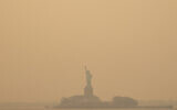 The Statue of Liberty, covered in a haze-filled sky, is photographed from the Staten Island Ferry, Wednesday, June 7, 2023, in New York. (AP Photo/Yuki Iwamura)