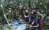In this photo released by Colombia's Armed Forces Press Office, soldiers and Indigenous men pose for a photo with the four Indigenous brothers who were missing after a deadly plane crash, in the Solano jungle, Caqueta state, Colombia, June 9, 2023. (Colombia's Armed Force Press Office via AP)