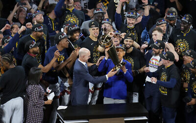 Denver Nuggets players, coaches and owners pose with the Larry O'Brien NBA Championship Trophy after their victory over the Miami Heat in Game 5 of basketball's NBA Finals, Monday, June 12, 2023, in Denver. (AP Photo/David Zalubowski)
