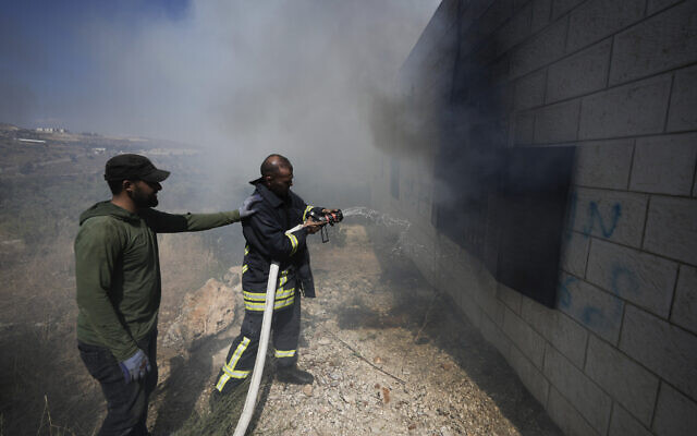 Palestinian firefighters try to extinguish a fire set by settlers in the West Bank town of Turmus Ayya, Wednesday, June 21, 2023. (AP Photo/Majdi Mohammed)