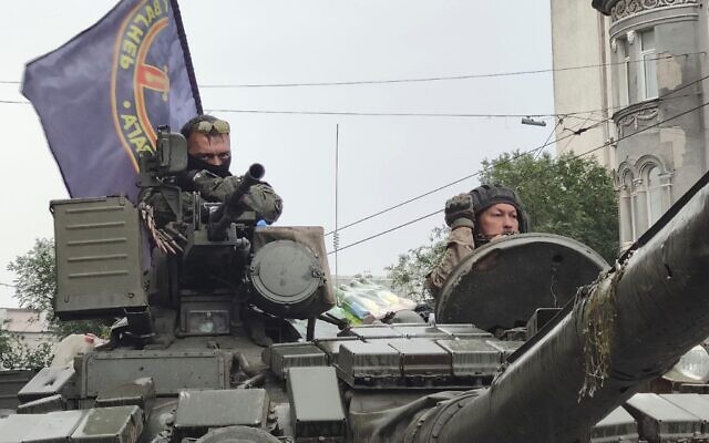 Servicemen sit in a tank with a flag of the Wagner Group military company, as they guard an area at the HQ of the Southern Military District in a street in Rostov-on-Don, Russia, June 24, 2023. (AP Photo)
