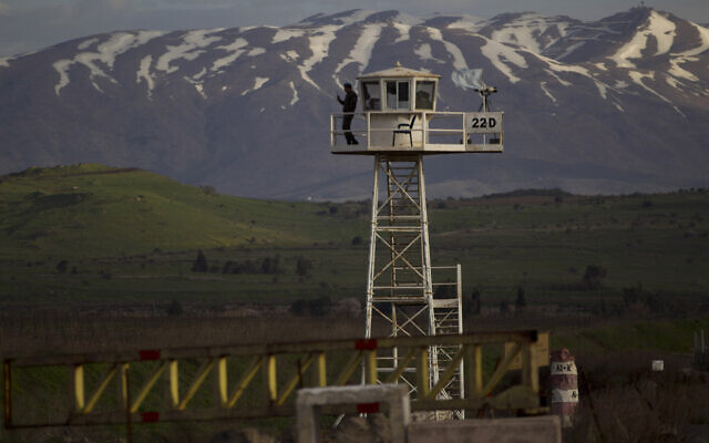 A UN peacekeeper from the UNDOF force stands guard on a watch tower at the Quneitra Crossing between Syria and Israel on the Golan Heights, Friday, March 8, 2013 (AP Photo/Ariel Schalit)