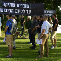 Left-wing NGO Breaking the Silence holds an event in Tel Aviv on July 1, 2017 where testimonies of former soldiers stationed in the West Bank were  read aloud in front of the Kirya military base. The sign reads: 'Breaking the silence until the occupation ends.' (Tomer Neuberg/Flash90)