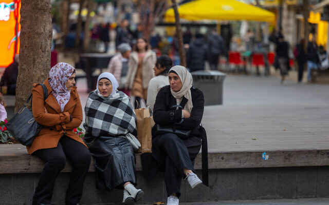 Arab women sit on a bench in central Jerusalem, on January 04, 2022. (Nati Shohat/Flash90)
