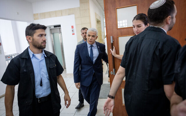 Opposition leader Yair Lapid arrives at the Jerusalem District Court to testify in Prime Minister Benjamin Netanyahu's graft trial on June 13, 2023. (Yonatan Sindel/Flash90)