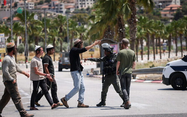 Israeli soldiers and settlers at the entrance to the West Bank town of Turmus Aya, June 21, 2023. (Yonatan Sindel/FLASH90)