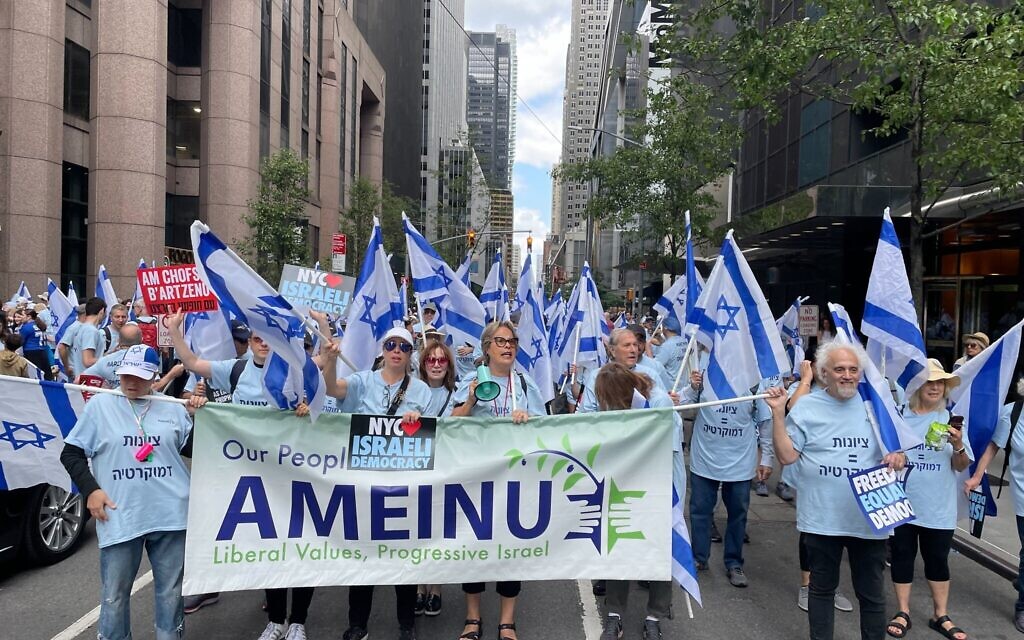Protesters march in New York wearing shirts reading 'Marching for democracy' and 'Zionism=democracy,' while waving Israeli flags and shouting chants from the anti-overhaul protest movement in Israel, June 4, 2023. (Luke Tress/Times of Israel)