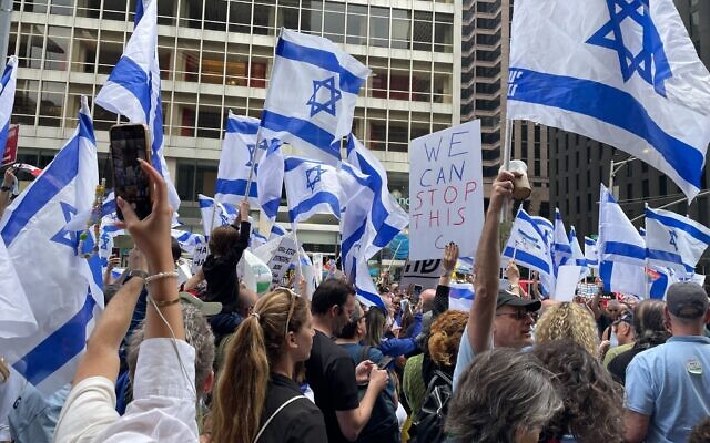 Anti-overhaul protesters gather outside the Hilton Midtown Hotel in New York City where ministers are taking part in an Arutz Sheva conference on June 4, 2023. (Luke Tress/Times of Israel)