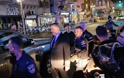 Anti-overhaul protesters rally against Energy Minister Israel Katz as he's escorted to his car in Tel Aviv, June 11, 2023. (Twitter screenshot: used in accordance with Clause 27a of the Copyright Law)