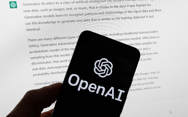 The OpenAI logo is seen on a mobile phone in front of a computer screen displaying output from ChatGPT, March 21, 2023. (AP Photo/Michael Dwyer, File)