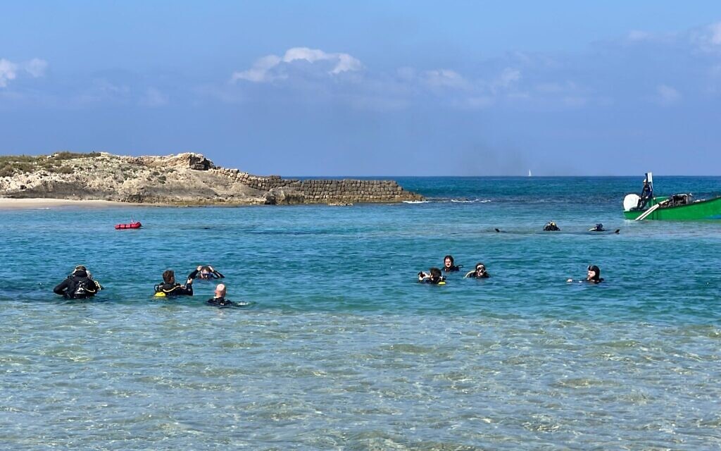 Students return from a marine archaeology excavation shift at Dor Beach on May 9, 2023. The lagoon at Dor Beach has 26 known archaeological sites containing shipwrecks or cargo. (Melanie Lidman/Times of Israel