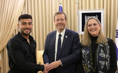 National soccer player Mohammad Abu Fani (left) meets with President Isaac Herzog (center) and First Lady Michal Herzog, in Jerusalem, June 20, 2023. (Amos Ben Gershom/GPO)