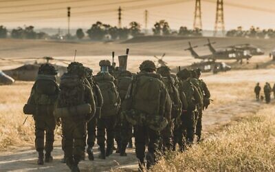 Israeli troops are seen near combat helicopters during a major military drill dubbed 'Firm Hand,' in a handout image published by the IDF on June 8, 2023. (Israel Defense Forces)