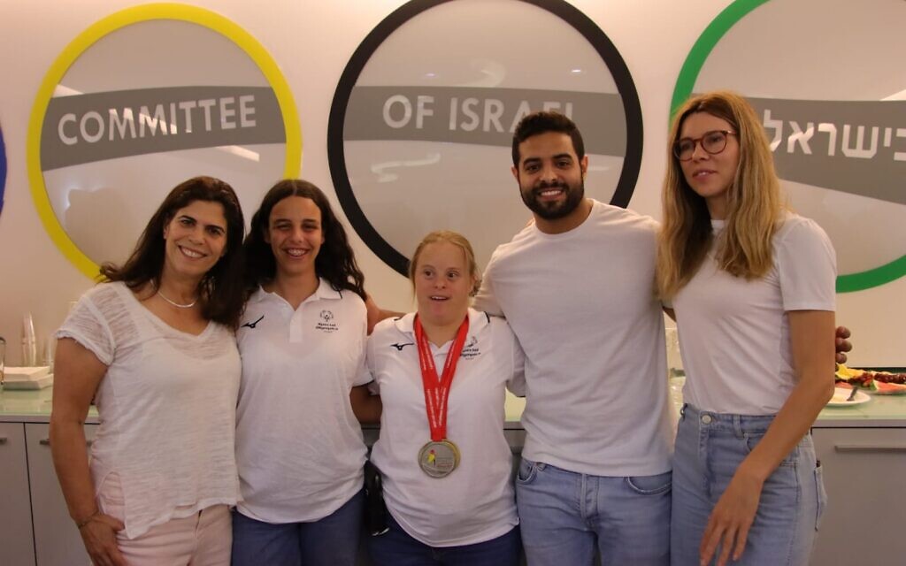 Past Israeli Olympians Yael Arad (left), Sagi Muki (second from right) and Hanna Minenko (right) pose for a photo with Special Olympics cyclists Tal Golani (center) and Noga Koren on June 8, 2023. (Ben Melnik)