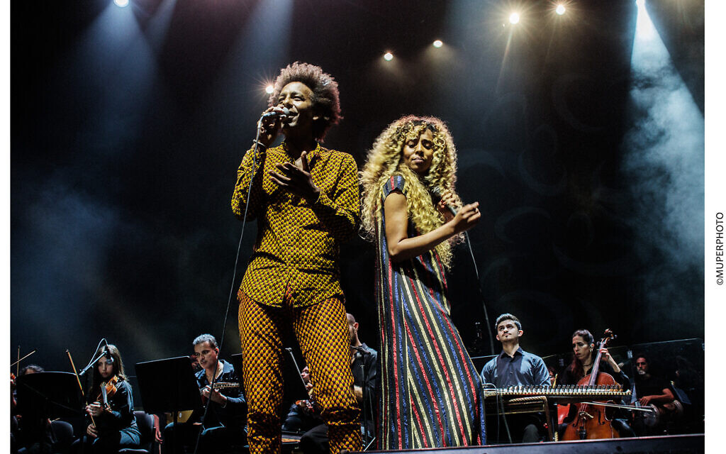 Gili Yalo (left) and Ester Rada (right) perform in 'Tazeta,' ('Nostalgia' in Amharic), a concert melding the sounds of jazz and pop from Ethiopian music, with conductor Tom Cohen and his East-West Orchestra on July 10, 2023 (Courtesy Israeli Opera)