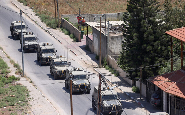 Israeli military armored vehicles advance on a road during an operation in Jenin, July 3, 2023. (RONALDO SCHEMIDT / AFP)
