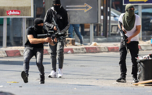 Palestinian gunmen take up positions during a confrontation with the Israeli army in the West Bank city of Jenin on July 3, 2023. (Jaafar ASHTIYEH / AFP)