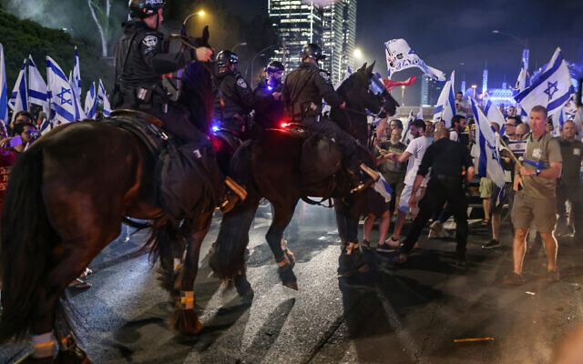 Mounted Israeli police officers try to disperse anti-government protesters on the Ayalon Highway in Tel Aviv on July 5, 2023. (OREN ZIV / AFP)
