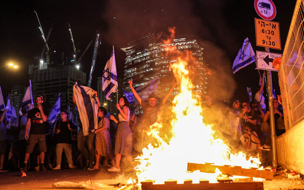 Demonstrators gather at a bonfire during a protest rally against the Israeli government's judicial overhaul, in Tel Aviv on July 24, 2023. (Jack Guez / AFP)