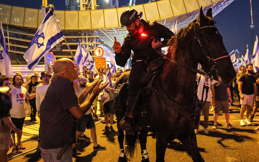 An Israeli mounted policeman confronts a demonstrator during a protest rally against the Israeli government's judicial overhaul, in Tel Aviv, on July 24, 2023.(Jack Guez / AFP)