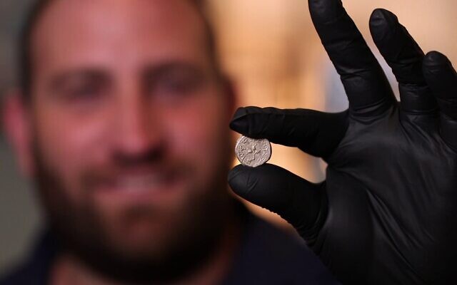 Yaniv David Levy, a numismatic scholar with the Israel Antiquities Authority, displays the 2,000-year-old coin from the first year of the Jewish revolt. (Emil Aladjem/IAA)