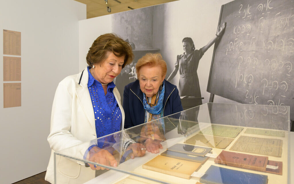 Lydia Barenholz and Ruth Melcer, who attended Munich's post-war Hebrew high school together, are shown with some of the objects they contributed to the new exhibit, 'Munich Displaced. The Surviving Remnant.' (Daniel Schvarcz via JTA)