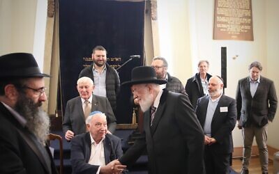Israel's former chief Ashkenazi rabbi Yisrael Meir Lau shakes hands with Holocaust survivor Felix Goldschmied at the Launceston Synagogue in Launceston, Australia, July 12, 2023. (Mishka Gora via JTA)